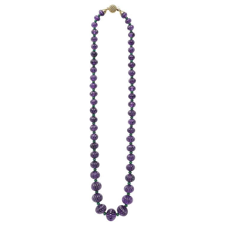 18k gold, hand carved fluted amethyst cabochon, and tsavorite garnet gemstones form this statement necklace.