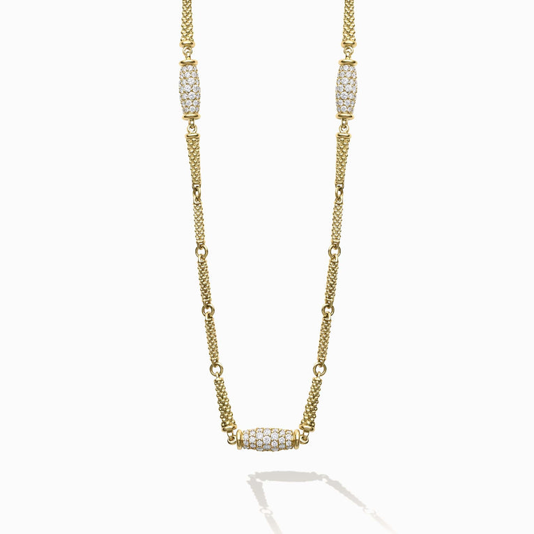 This 18K Caviar Gold Necklace features three barrel stations, adorned in brilliant diamonds.
