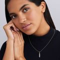 Woman wearing nine bezel-cut diamond pendant on a 18K gold beaded chain with white background