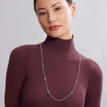 Young woman wearing the Rare Wonders Five Station Honeybee Necklace with hexagonal links and bee-shaped charms on a silver chain, showcasing elegant LAGOS craftsmanship.