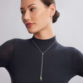 Woman wearing KSL Pyramid Lariat Necklace, featuring pyramids of 18K gold and sterling silver, elegantly styled with a fitted black turtleneck.