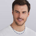 Man wearing LAGOS Silver Station Matte Blue Caviar beaded ceramic necklace with sterling silver lobster clasp, ultramarine
