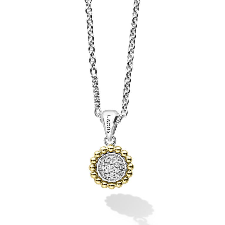 A diamond circle pendant set in sterling silver with 18k gold Caviar detailing on a chain necklace. LAGOS diamonds are the highest quality natural stones.