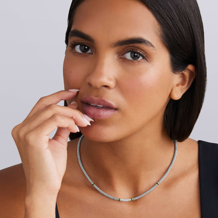 woman wearing sterling silver beaded statement necklace with black ceramic and gold stations and diamonds