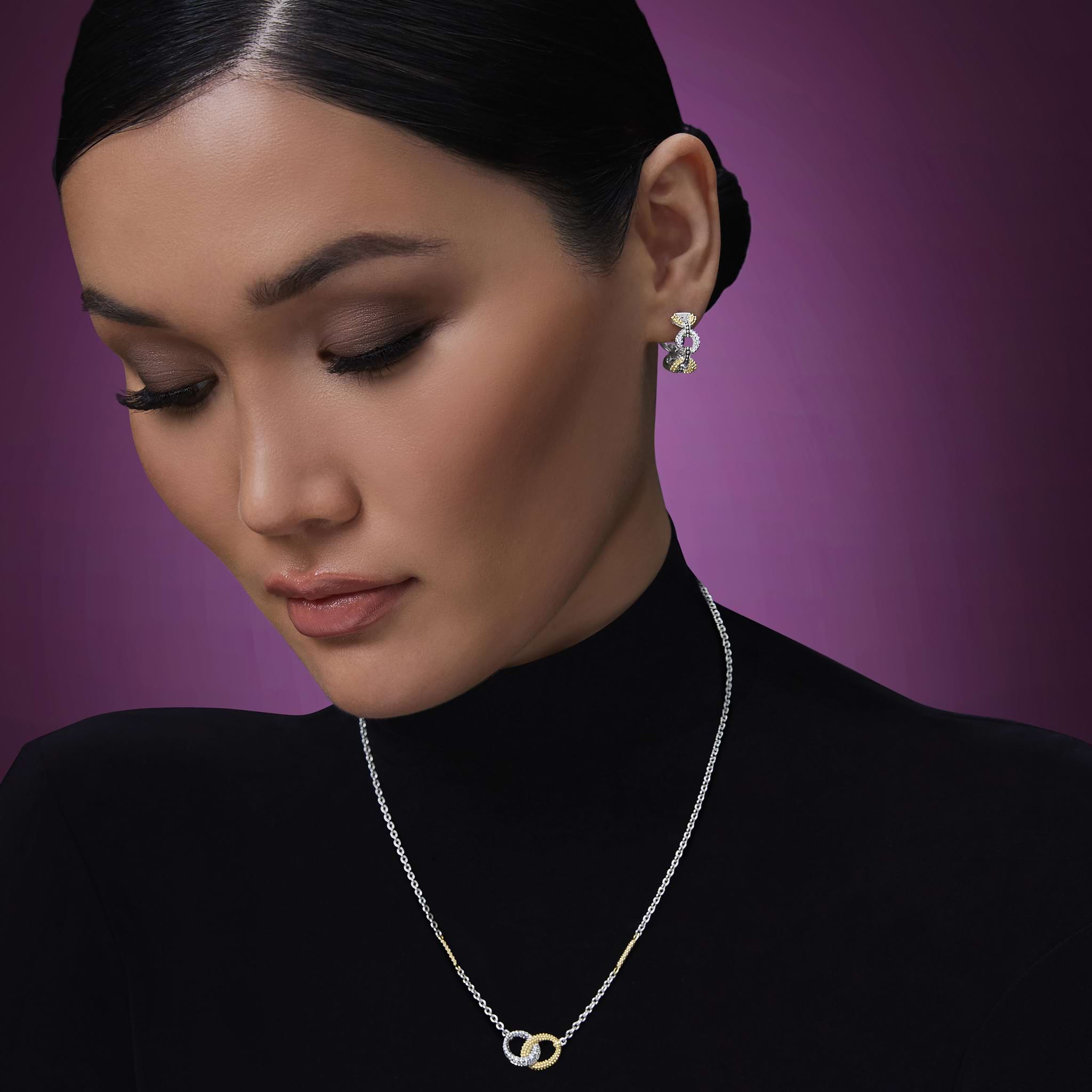 woman wearing sterling silver and gold link hoop earrings with diamonds and gold and silver diamond necklace