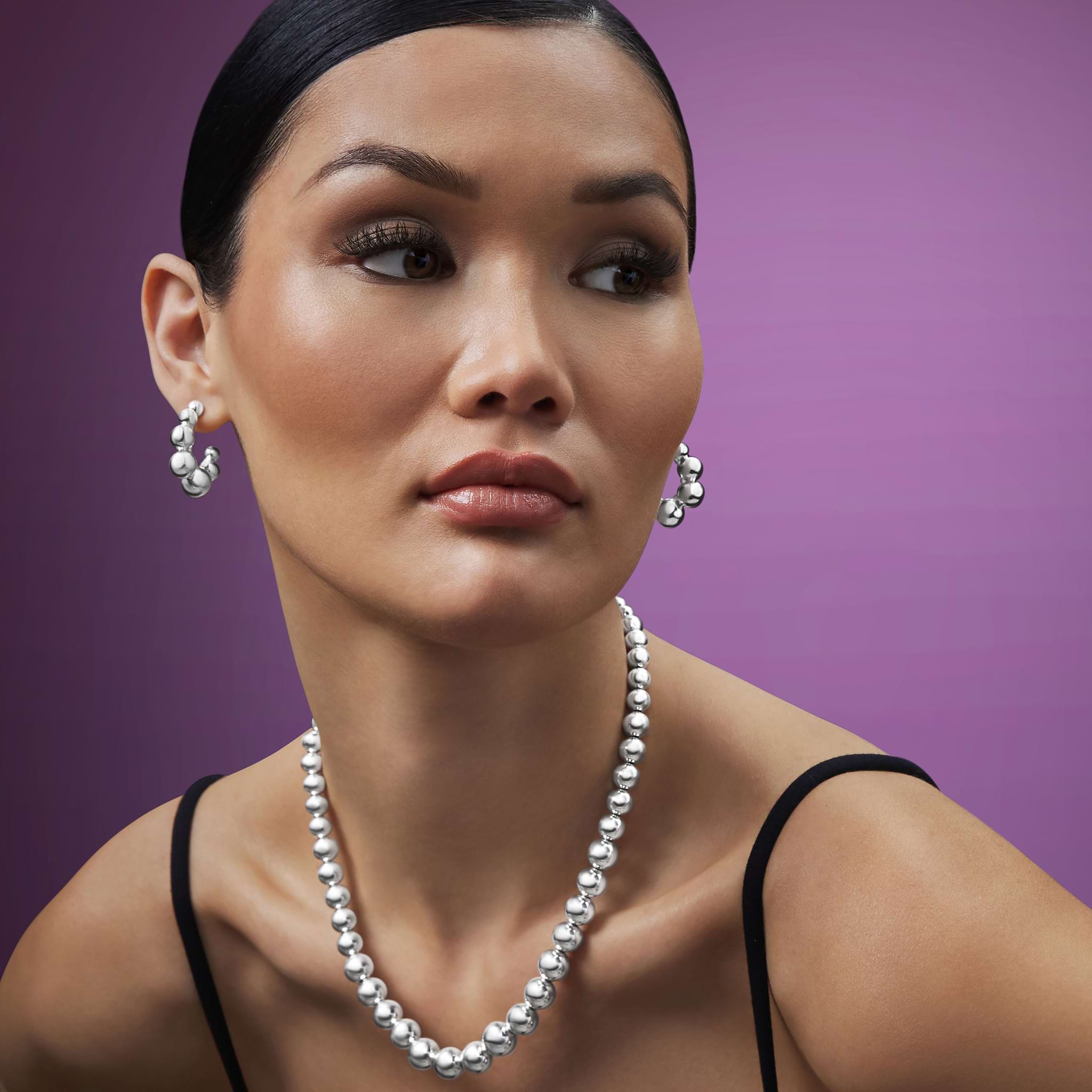 woman wearing sterling silver necklace and earrings beads increasing from small to bigger