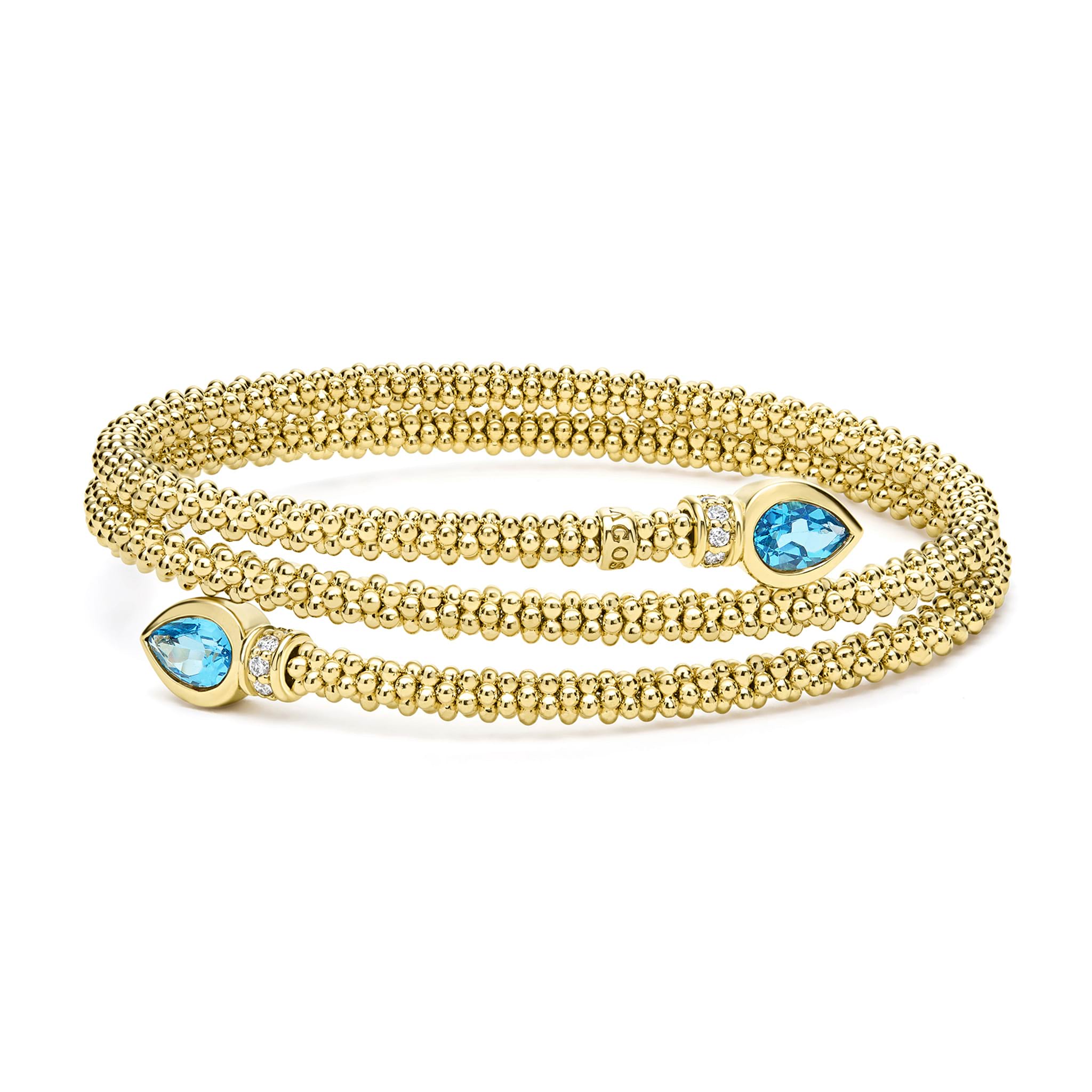 Two pear-shaped swiss blue topaz gemstones are accented by diamonds and set in 18k gold Caviar beading to form this luxe wrap bracelet. LAGOS diamonds are the highest quality natural stones.