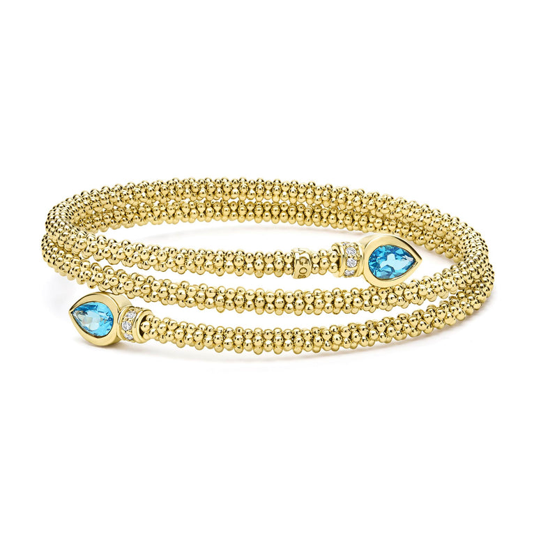 Two pear-shaped swiss blue topaz gemstones are accented by diamonds and set in 18k gold Caviar beading to form this luxe wrap bracelet. LAGOS diamonds are the highest quality natural stones.