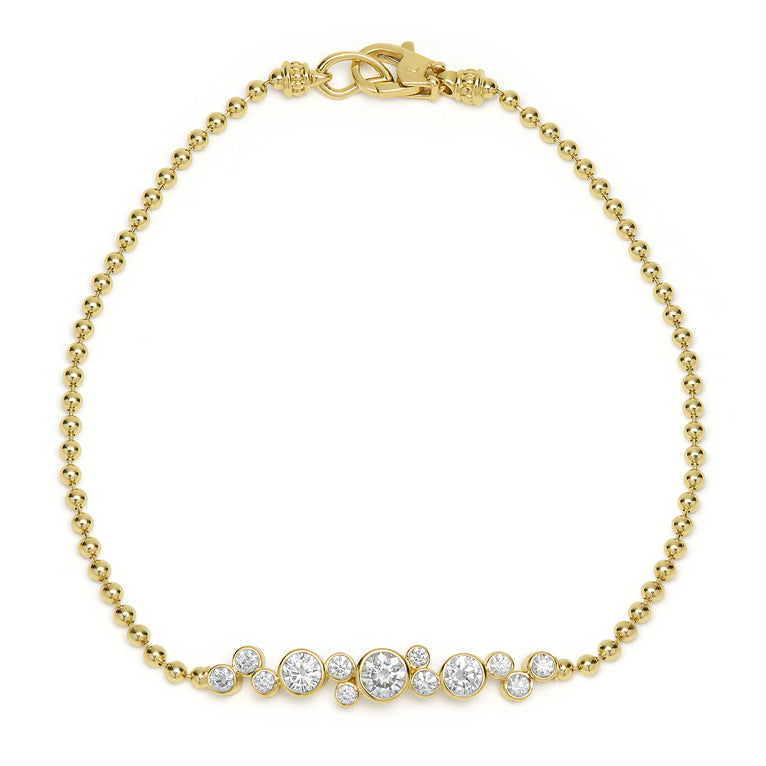 A delicate gold beaded bracelet, sparkling with a graduated row of bezel-set diamonds, finished with a secure lobster clasp for timeless elegance.