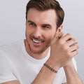 man wearing 18K gold and matte black ceramic oval link bracelet, 7 mm, lobster clasp