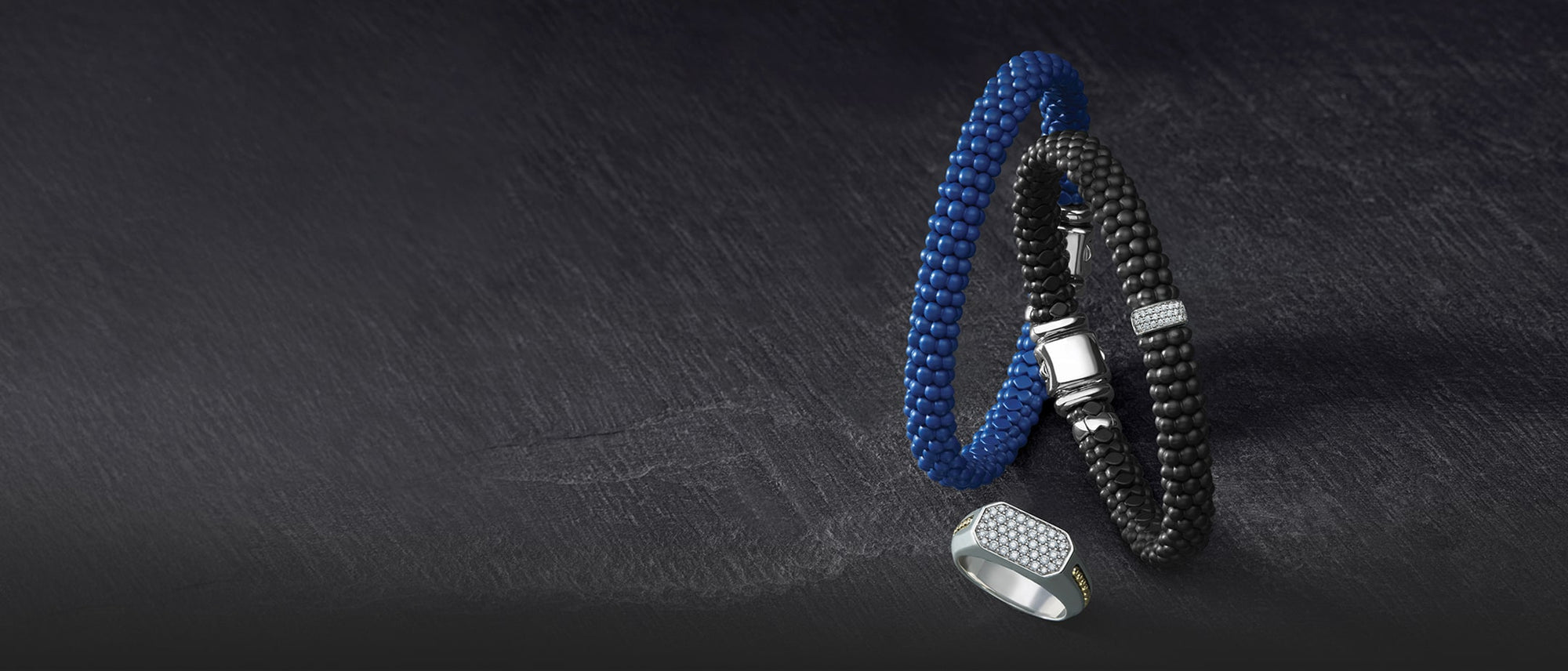 Black and blue ceramic beaded bracelets with a silver ring on a dark surface