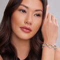 Young woman wearing the Signature Caviar Two-Tone Oval Link Bracelet, featuring sterling silver and 18K gold links, showcasing LAGOS elegant craftsmanship.