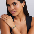 woman wearing thick sterling silver beaded bracelet with gold x details