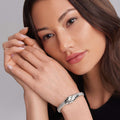 Woman's face with pale-pink nails frames her face, highlighting the Keep Memory Alive Caviar Beaded Bracelet, a chunky silver piece with a chain-mail design.