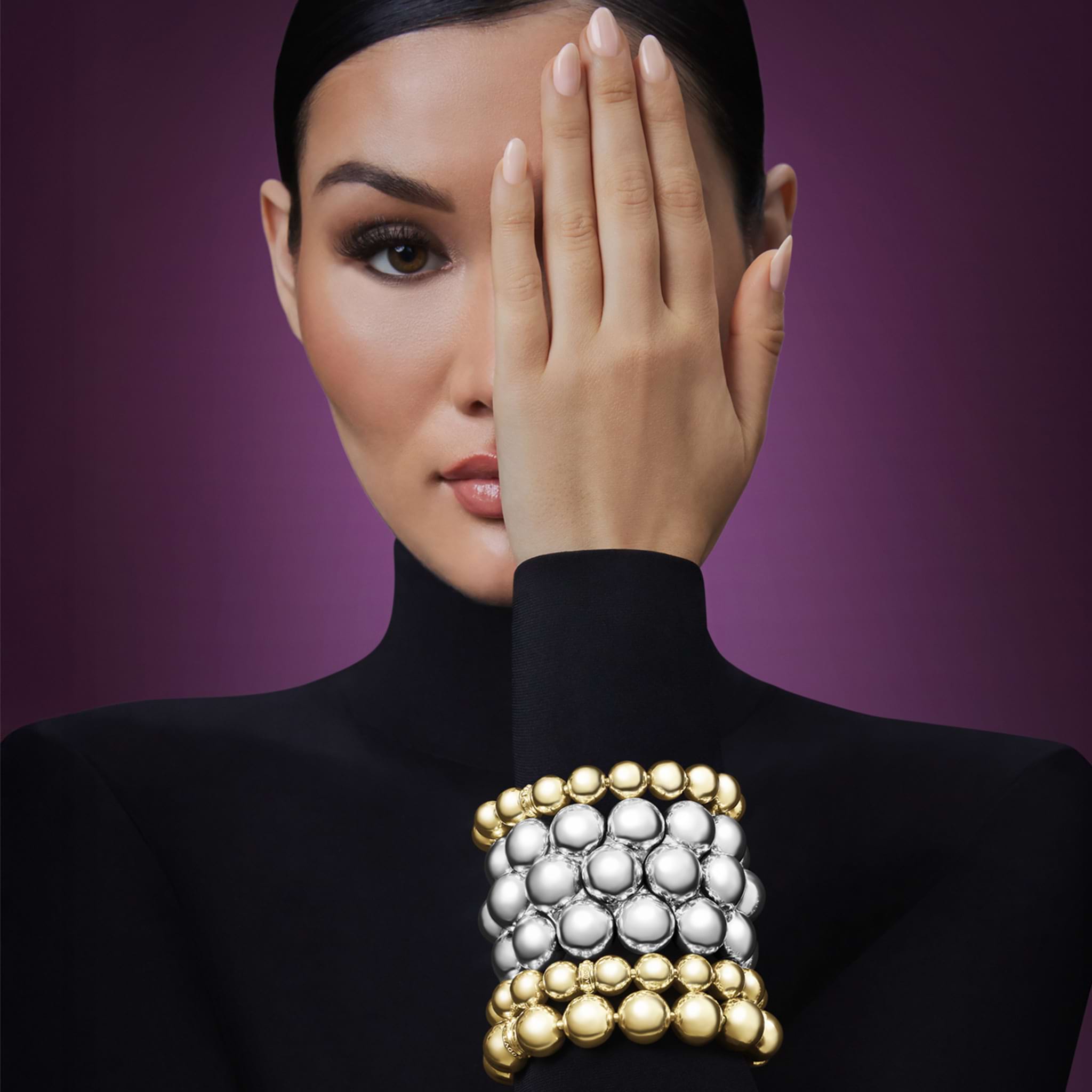 woman wearing gold and sterling silver beaded statement bracelets 