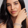 Woman showcasing Signature Caviar Silver Bangle Set; three sterling silver bangles with Caviar beading.