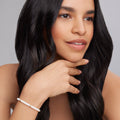 Close-up of a woman wearing the White Caviar Five Gold Station Ceramic Bracelet, showcasing white ceramic beads and 18K gold accents on the wrist.
