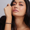 Close-up of a woman wearing the Black Caviar Black Five Silver Station Ceramic Bracelet, showcasing sleek black ceramic beads and polished sterling silver accents.