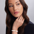 White Caviar Single Station Ceramic Diamond Bracelet on womans wrist, showcasing 18K gold accents and a diamond station.