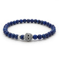 Lapis gemstones accented with a sterling silver Caviar beaded skull form this stretch bracelet.