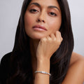 Woman wearing Signature Caviar Love Stretch Bead Bracelet with engraved LOVE plate, showcasing its sterling silver Caviar beading.