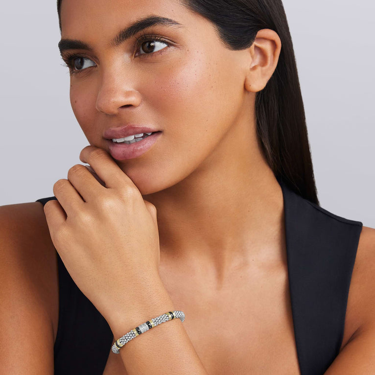 woman wearing 6mm sterling silver beaded diamond bracelet with black ceramic and gold stations