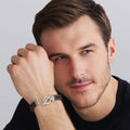 Man wearing a bracelet with a gray background