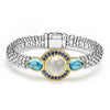 A round moonstone, blue sapphires, and pear-shaped blue topaz gemstones are set in smooth 18k gold on this sterling silver Caviar rope bracelet.