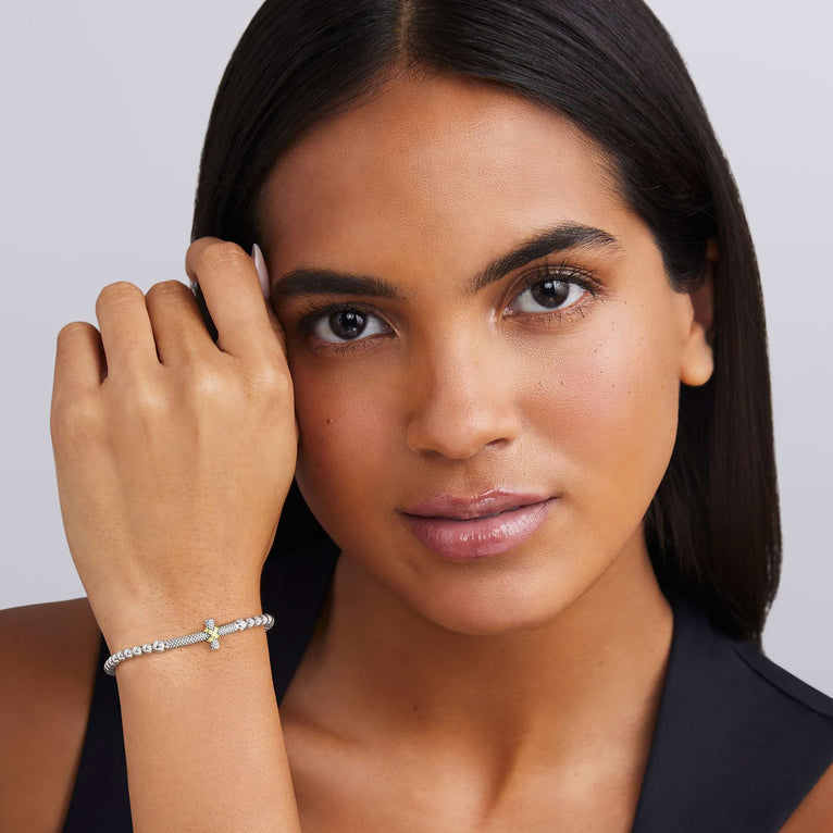 woman wearing everyday stretch bracelet with beaded sterling silver and gold cross detail