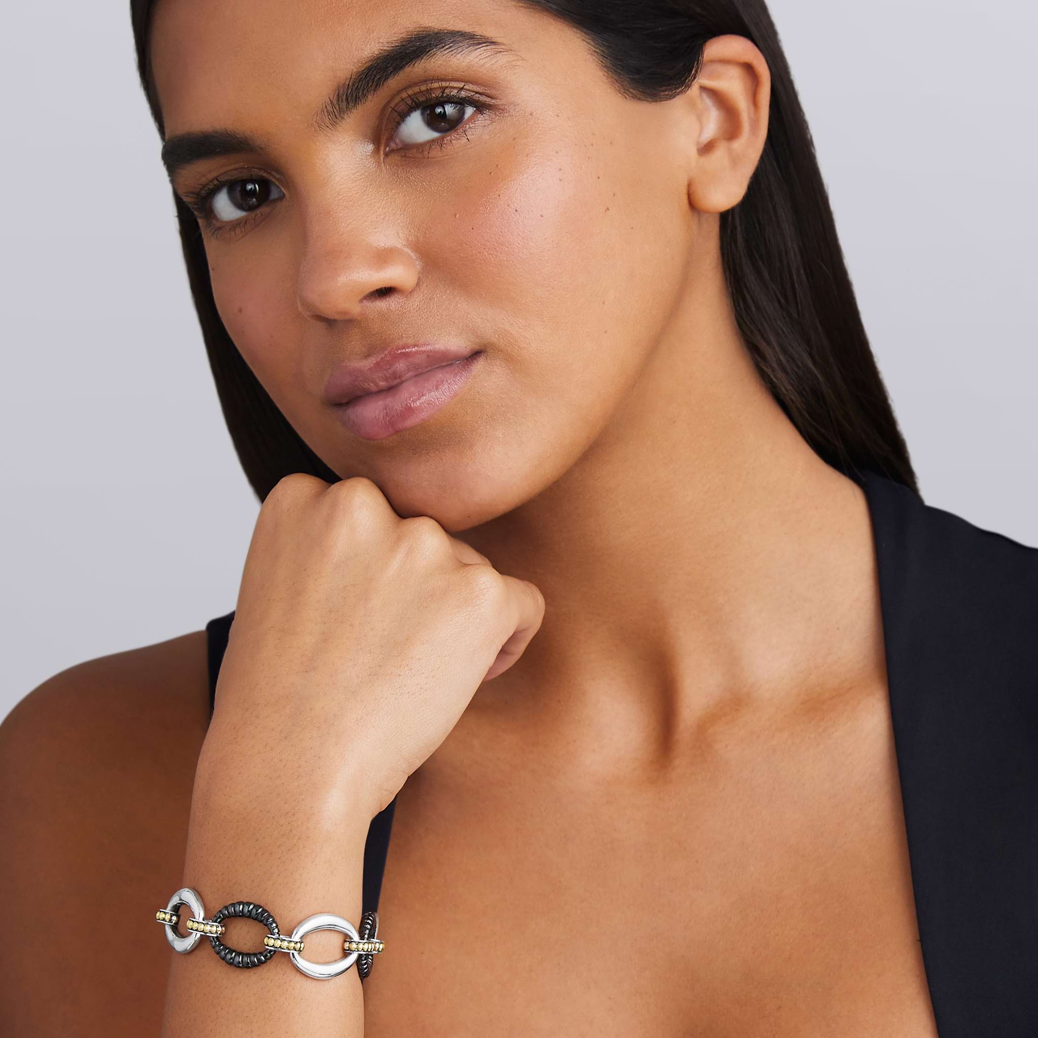 woman wearing sterling silver link bracelet with gold and black ceramic beading 