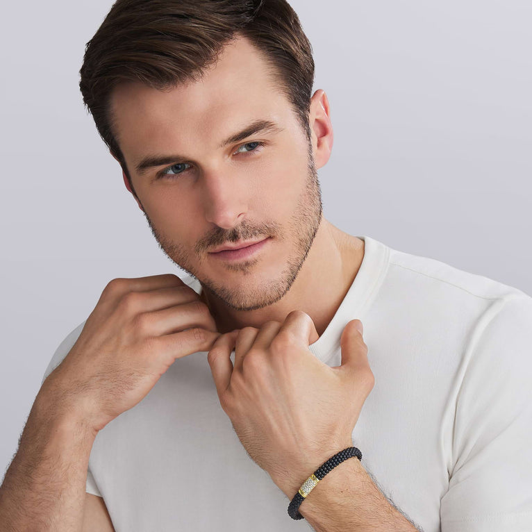 man wearing LAGOS 18K Gold matte black ceramic Caviar bracelet with diamond station, 9mm