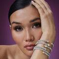woman wearing three silver and gold bracelets on wrist