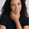 Young woman wearing the Signature Caviar Petite Sterling Silver Link Bracelet, a refined, lightweight accessory ideal for layering, crafted in luminous sterling silver.