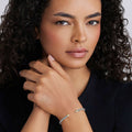 Young woman wearing the Signature Caviar Two-Tone Mini Versa Torque Bracelet in polished sterling silver with gold accents, featuring textured Caviar beading.