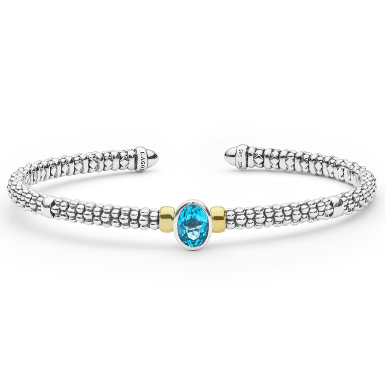 Signature Caviar Two-Tone Swiss Blue Topaz Oval Mini Versa Torque Bracelet features a sterling silver cuff with caviar beading, a central blue topaz, and 14K gold accents.