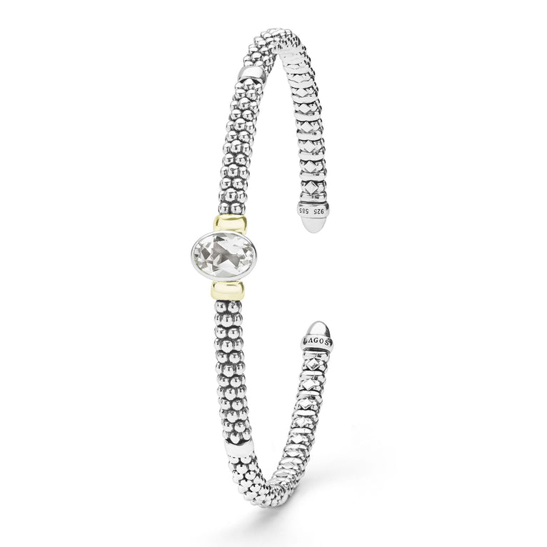 Signature Caviar Two-Tone White Topaz Oval Mini Versa Torque Bracelet features sterling silver caviar beading, 14K gold accents, and a central faceted white topaz gemstone.