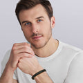 Man wearing Anthem Black Braided Vegan Leather and Two-Tone Bracelet with sterling silver accents, showcasing a modern, masculine style on his wrist.