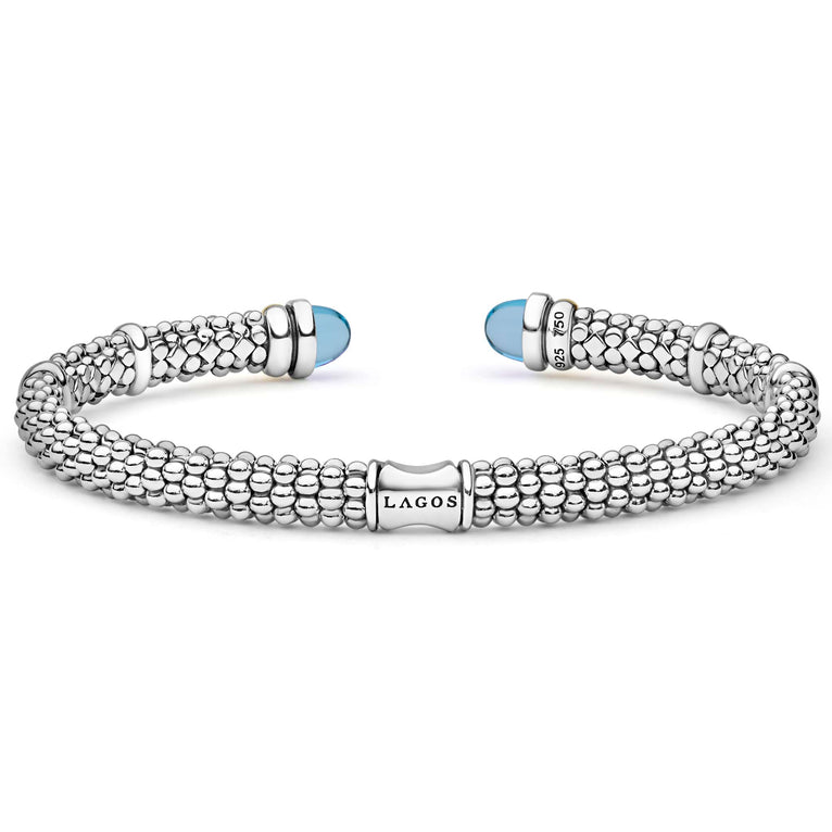 Signature Caviar Two-Tone Swiss Blue Topaz Versa Torque Bracelet in sterling silver with 14K gold accents, featuring caviar beading and vivid sky-blue cabochon end caps.