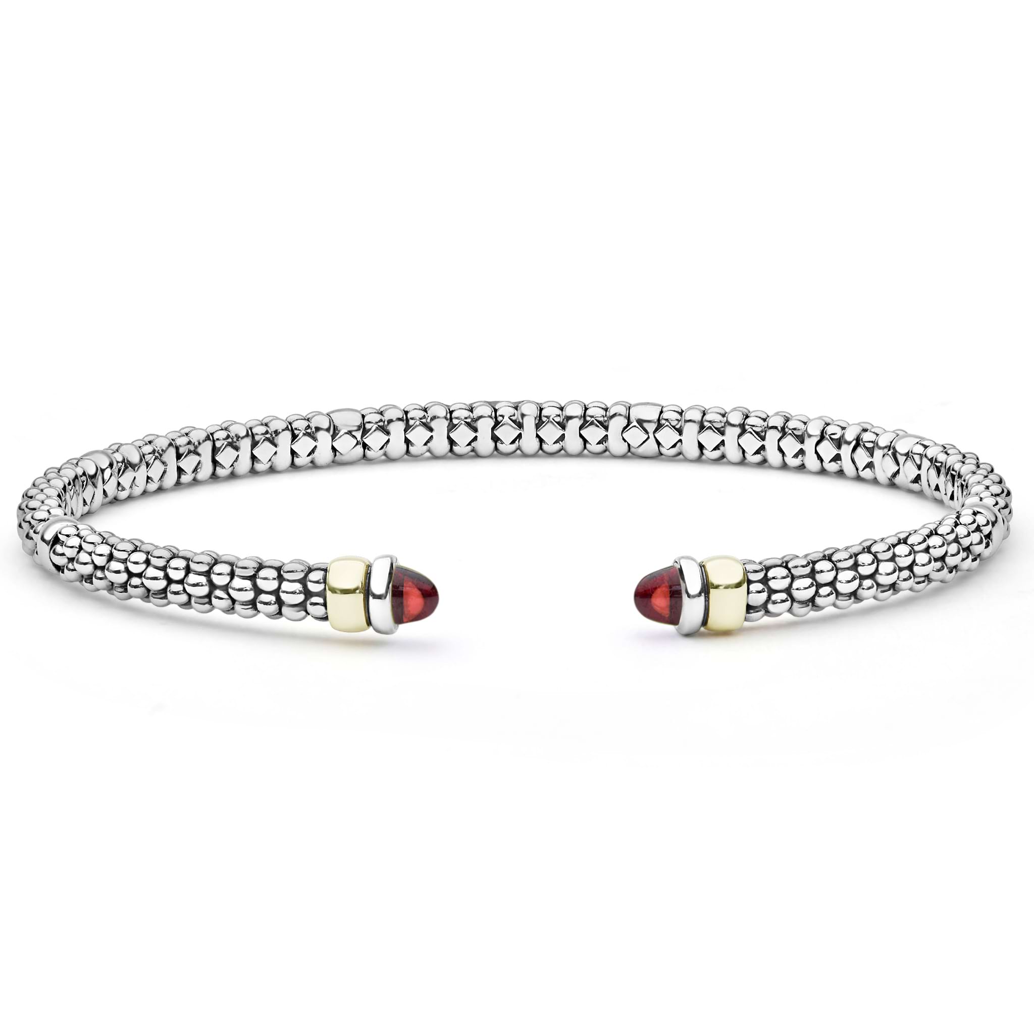 A sterling silver cuff bracelet with 14K gold accents, featuring caviar beading and garnet gemstone tips.