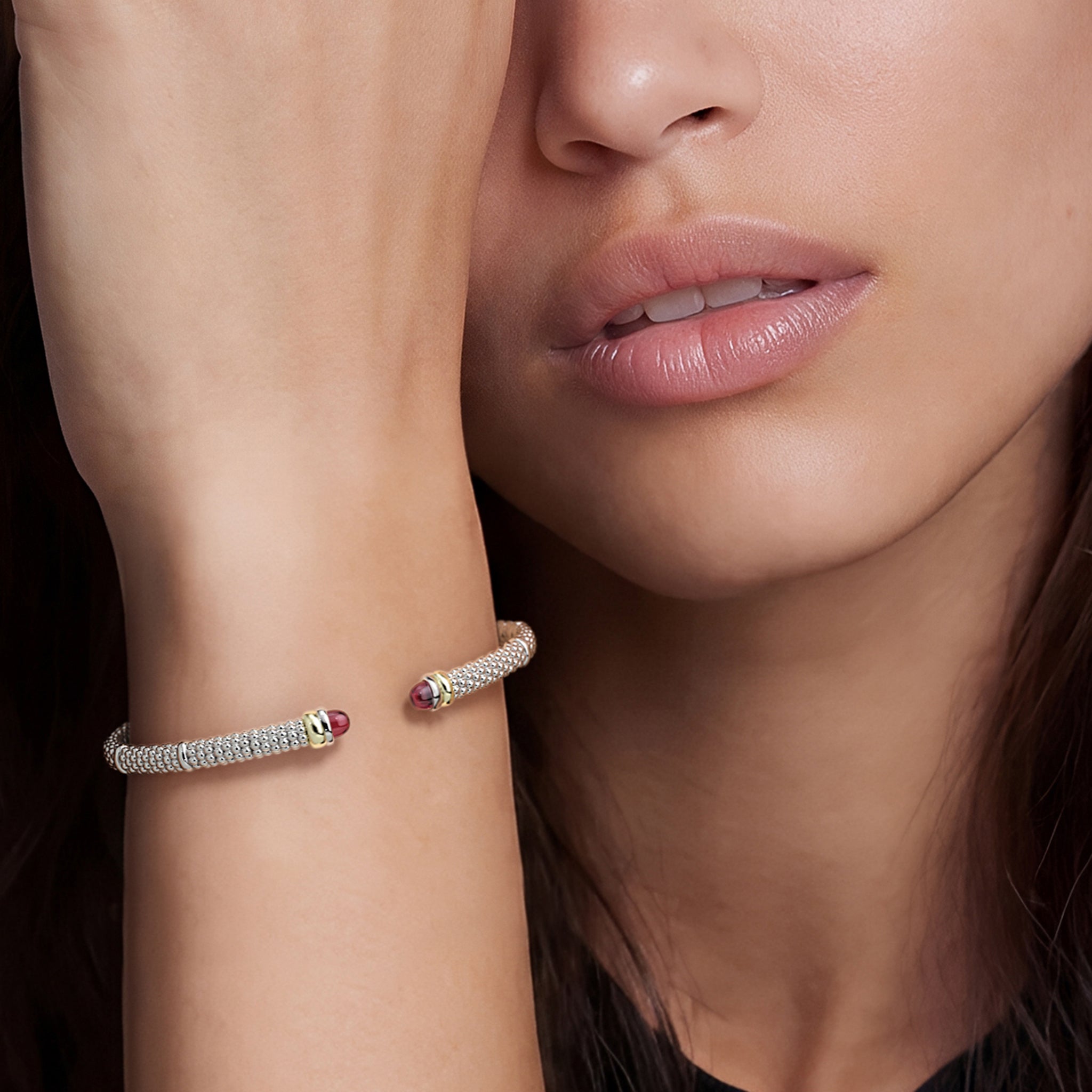 Woman wearing the Two-Tone Garnet Mini Versa Torque Bracelet on her wrist