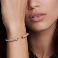 Woman wearing the Two-Tone Garnet Mini Versa Torque Bracelet on her wrist