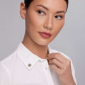 Woman wearing a crisp white shirt touches the collar adorned with the Rare Wonders Small Honeybee Pin featuring intricate 18K gold beading and black rhodium accents.