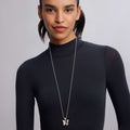Person wearing a fitted black top with a sterling silver Rare Wonders Butterfly Pendant Necklace on a beaded chain, showcasing LAGOS's craftsmanship and elegant design.