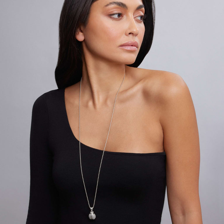 Woman wearing the Rare Wonders Silver Ladybug Pendant Necklace, a sterling silver piece with caviar beading, displayed against a light background, capturing LAGOS elegance.