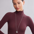 Young woman wearing a Keep Memory Alive Heart Pendant Necklace with a textured heart-shaped pendant on a silver beaded chain, reflecting LAGOS elegance and quality.
