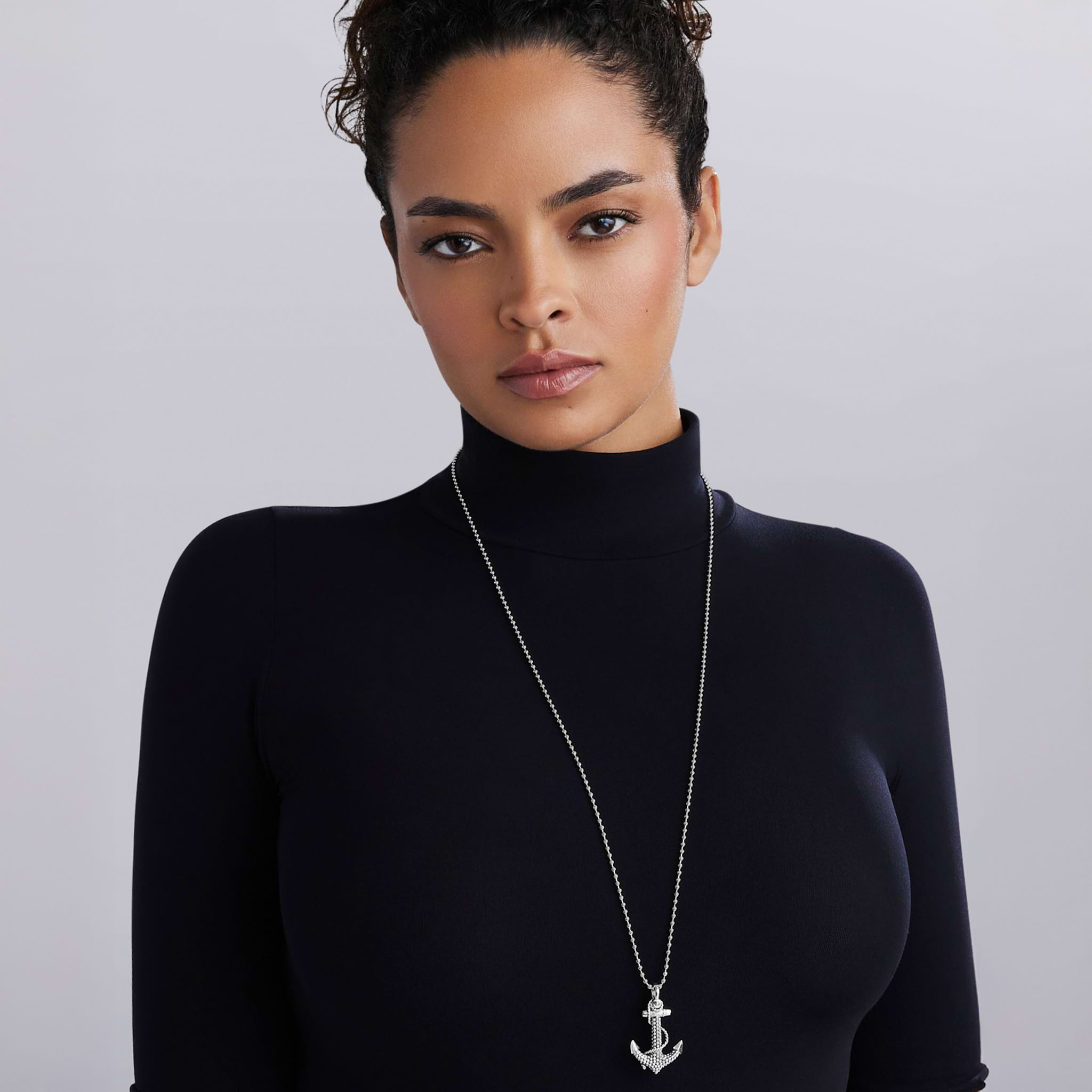 Woman wearing Signature Caviar Sterling Silver Anchor Pendant Necklace featuring a detailed anchor with Caviar beading on a polished ball chain, reflecting refined craftsmanship.