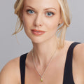 Young woman wearing a Rare Wonders Olive Quartz Diamond Beetle Pendant Necklace with a delicate chain, showcasing fine craftsmanship in 18K gold and sterling silver accents.
