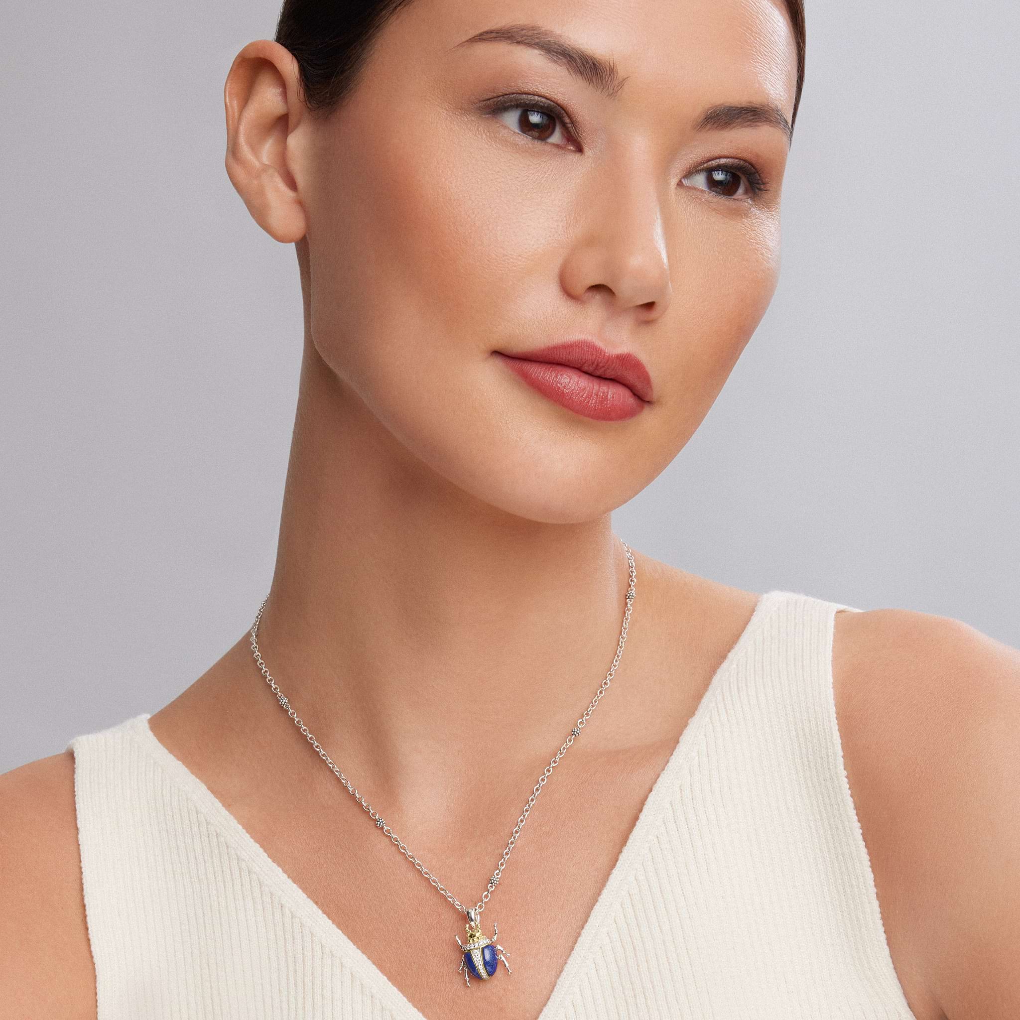 Woman wearing Rare Wonders Lapis Beetle Diamond Pendant Necklace with a blue beetle, gold accents, and sterling silver Caviar beaded stations on a silver chain.