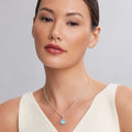 Maya Small Ceramic Circle Pendant Necklace with turquoise center and sterling silver Caviar beading on a delicate chain, worn by a woman in a white tank top.