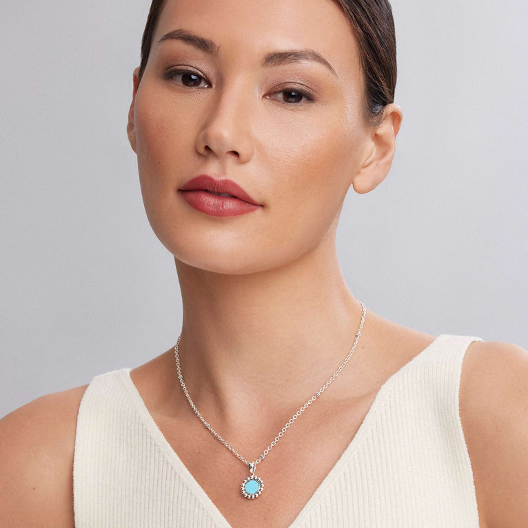 Maya Small Ceramic Circle Pendant Necklace with turquoise center and sterling silver Caviar beading on a delicate chain, worn by a woman in a white tank top.